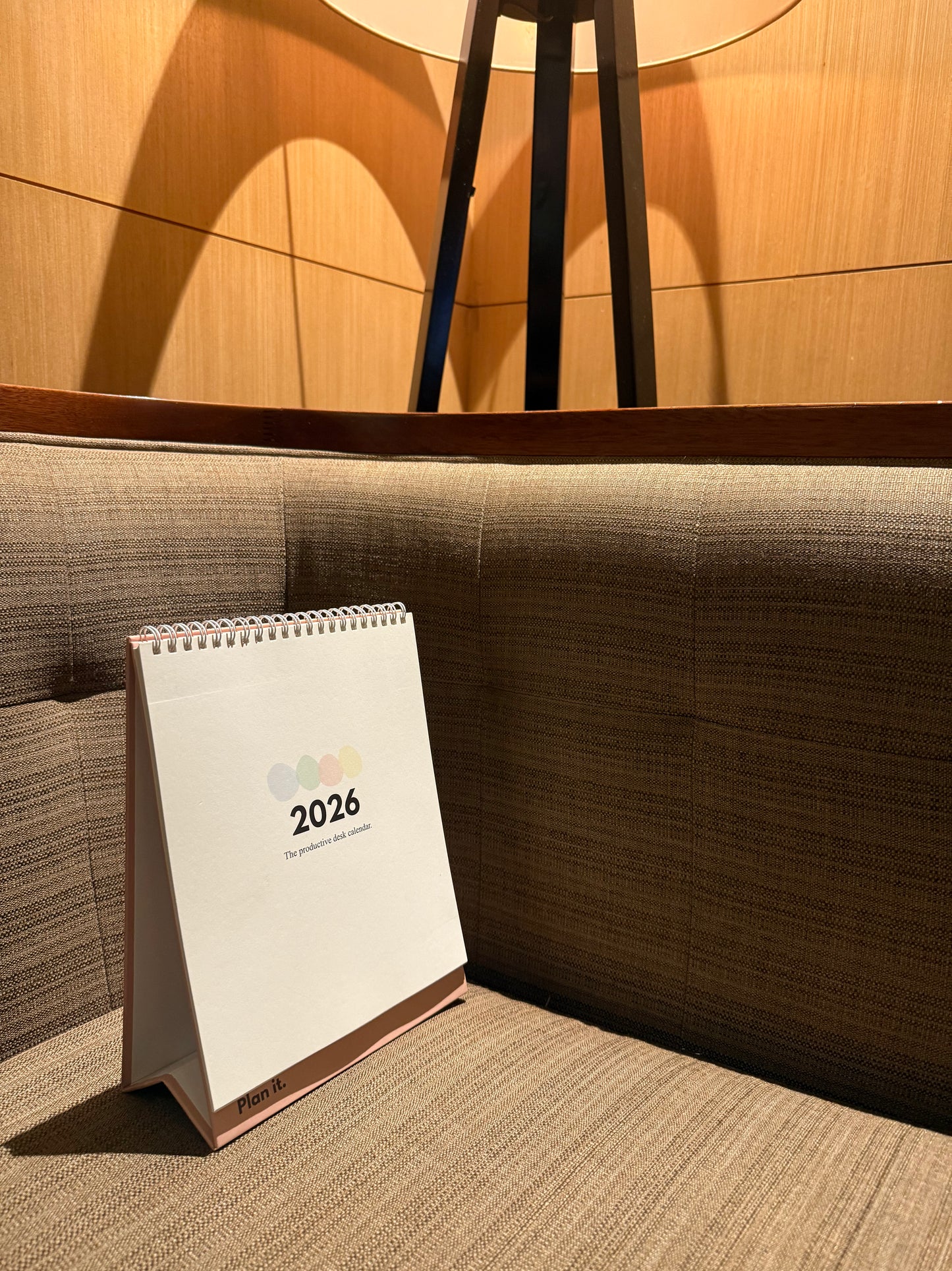 Desktop Calendar for 2026 on a table in a room with wooden walls and a brown cushioned bench in Sri Lanka